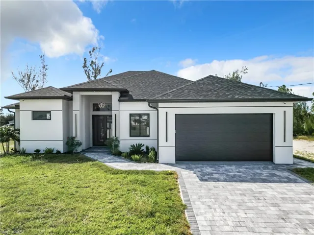 View of front of property with a front lawn and a garage