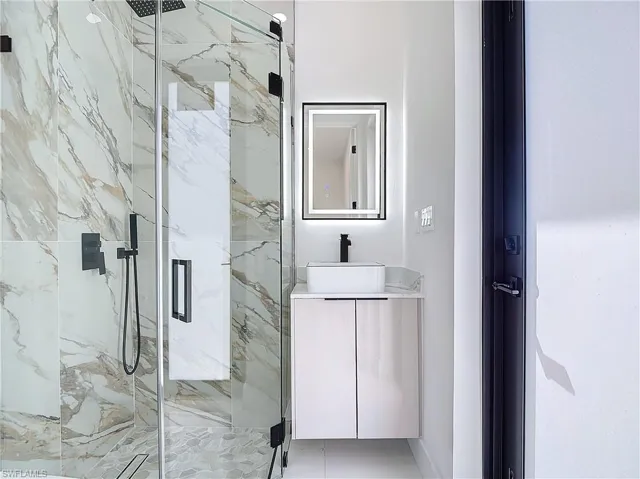 Bathroom featuring vanity and an enclosed shower