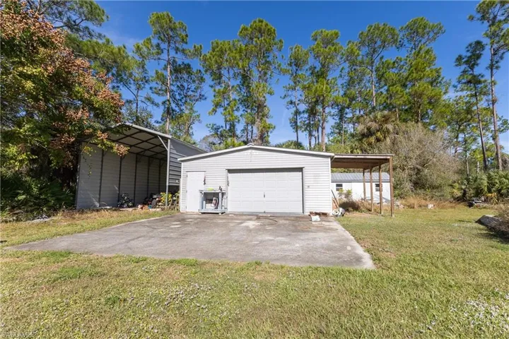 Garage featuring a detached garage and driveway