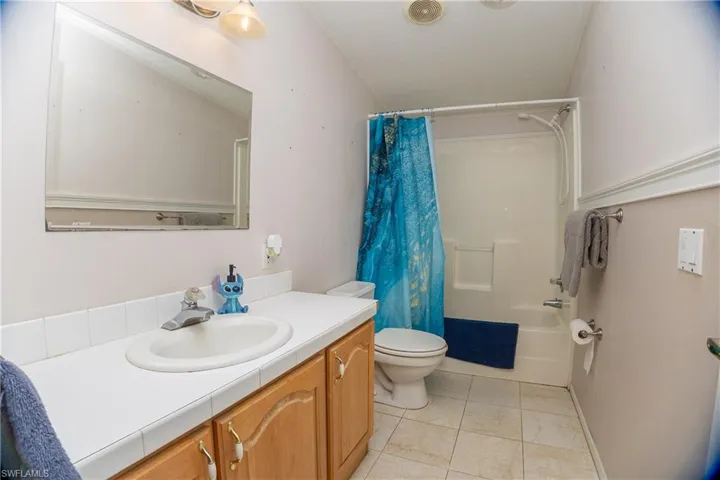 Full bathroom featuring vanity, shower / tub combo, and light tile patterned floors