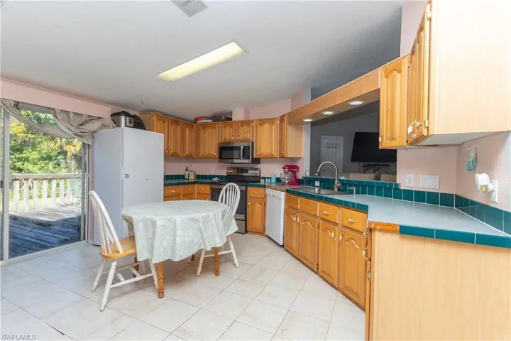 Kitchen featuring stainless steel appliances and light tile patterned flooring