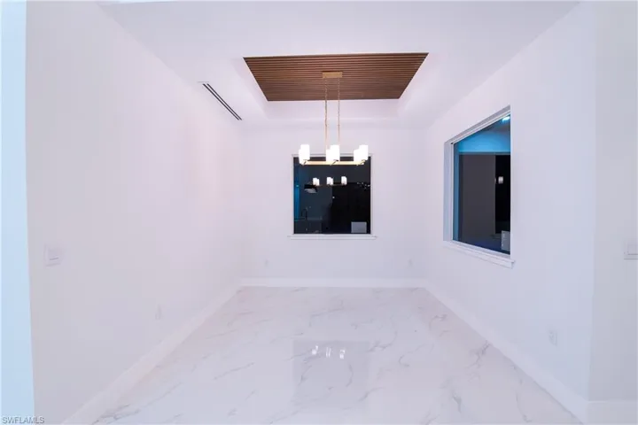 Spare room with a raised ceiling and a notable chandelier