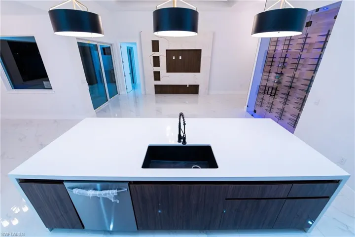 Kitchen with hanging light fixtures, sink, and dishwasher