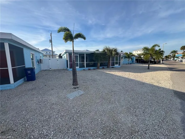 View of yard featuring a sunroom and a gate