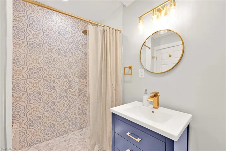 Full bathroom with vanity and a shower stall