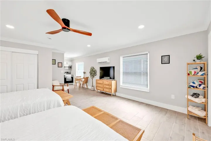 Bedroom featuring light wood-style flooring, a closet, recessed lighting, ornamental molding, and ceiling fan