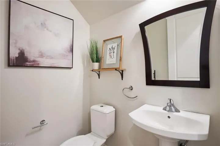 Bathroom featuring lofted ceiling, toilet, and sink