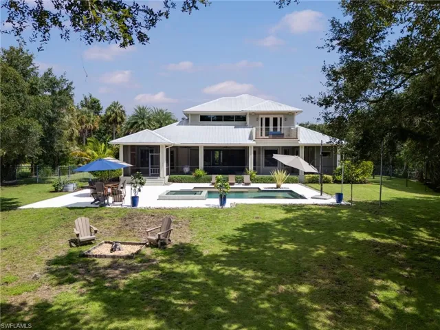 Rear view of property featuring a lawn, fire pit. pool, screen patio and 2nd story sun deck