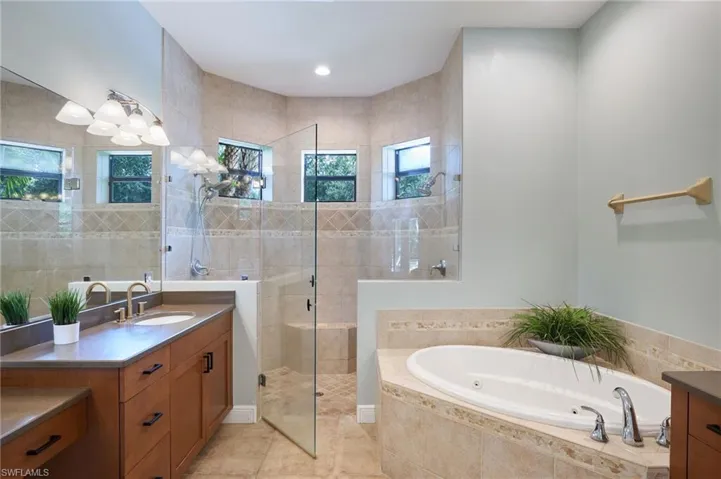 Bathroom featuring vanity, plus walk in shower, and tile floors