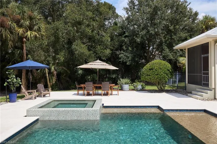View of swimming pool with an in ground spa and a patio area