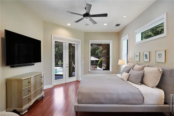 Primary Bedroom featuring access to outside/pool, dark wood-type flooring, and ceiling fan