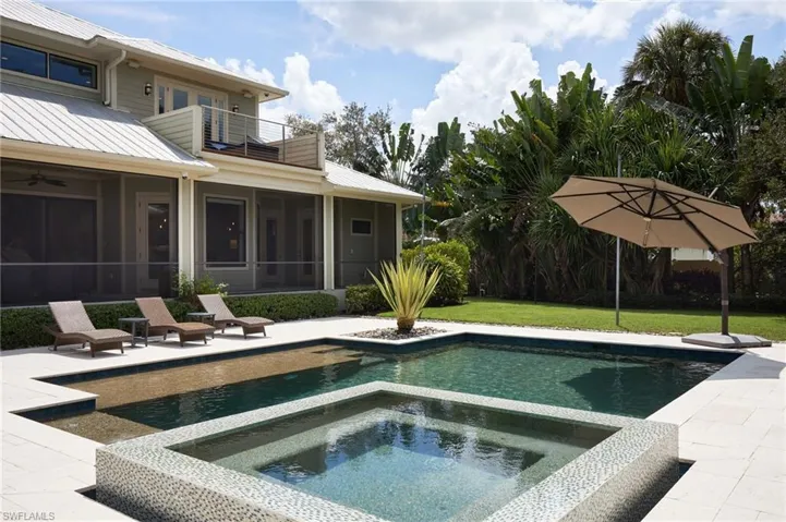 View of swimming pool with a patio, a lawn, and an in ground spa