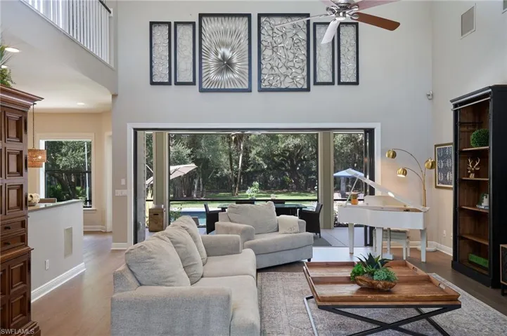 Living room featuring a high ceiling, ceiling fan, and hardwood / wood-style flooring