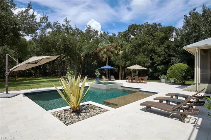 View of swimming pool featuring a lawn, an in ground pool and spa, and patio area