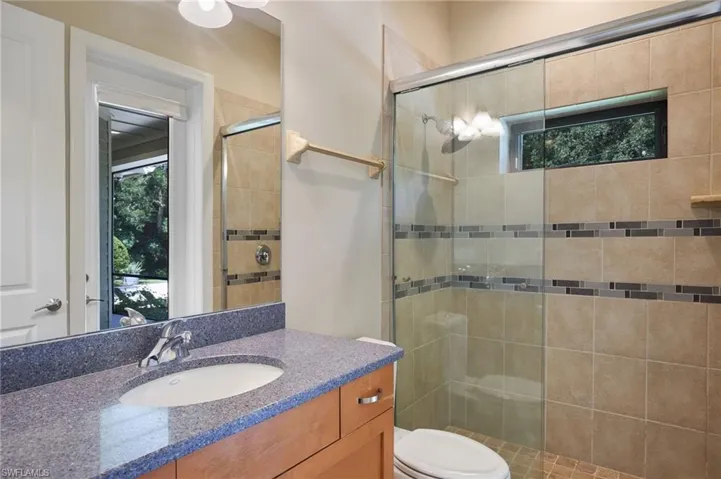 Bathroom with vanity, toilet, and an enclosed shower
