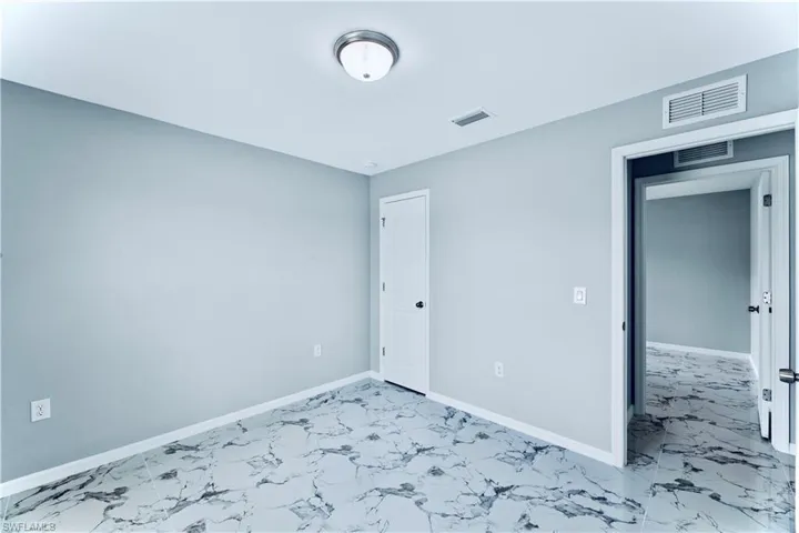 Unfurnished bedroom featuring light tile floors