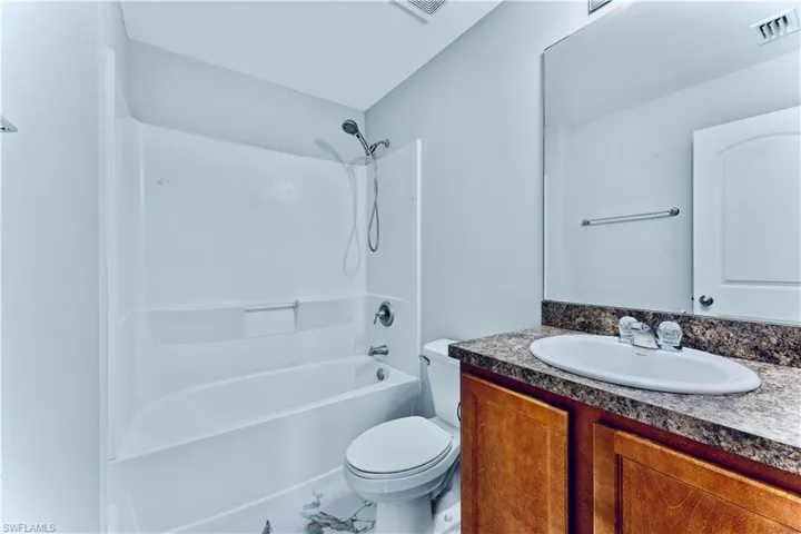 Full bathroom with tile flooring, vanity, toilet, and bathing tub / shower combination