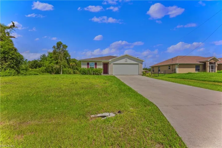 Ranch-style house with a garage and a front yard