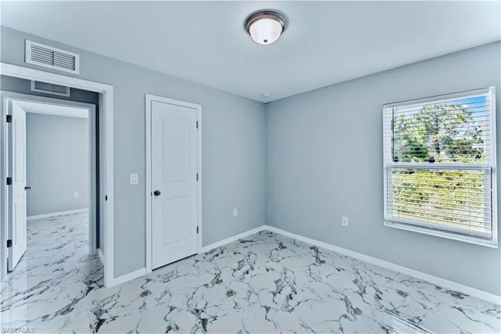 Unfurnished room with light tile flooring