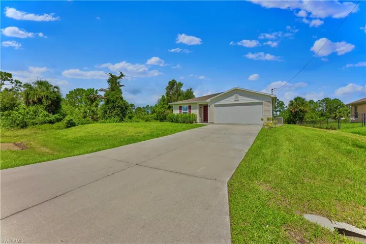 View of front of house with a garage and a front lawn