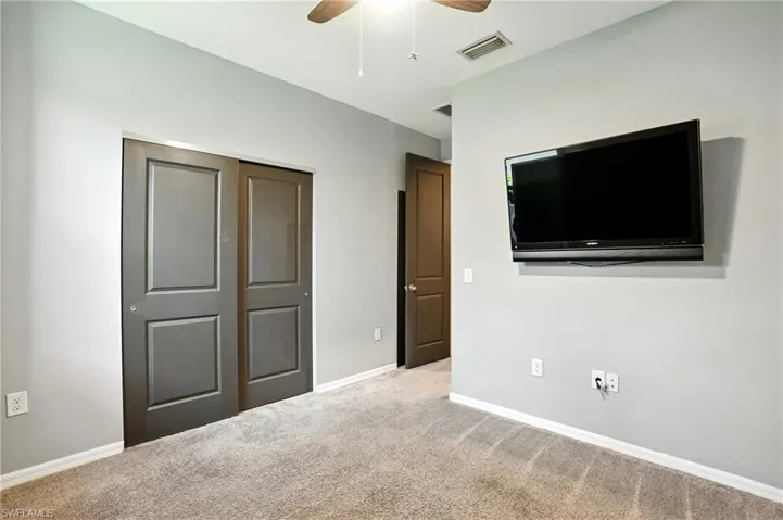Unfurnished bedroom featuring carpet flooring, a closet, and a ceiling fan