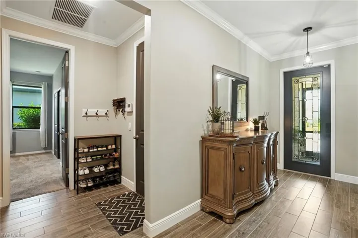 Entryway featuring plenty of natural light, wood tiled floors, and ornamental molding
