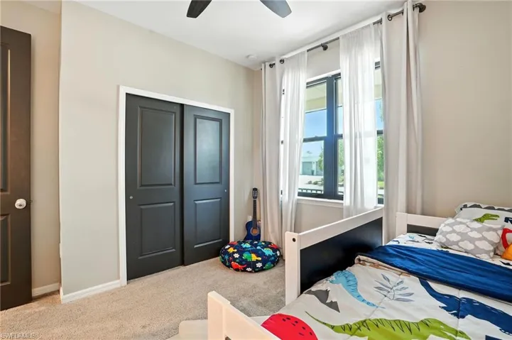 Bedroom featuring carpet flooring, ceiling fan, and a closet