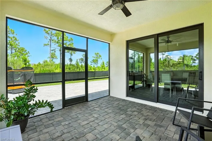 Unfurnished sunroom featuring a patio and ceiling fan
