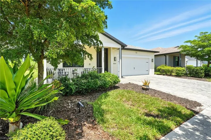 View of front of property featuring decorative driveway, stucco siding, and a garage