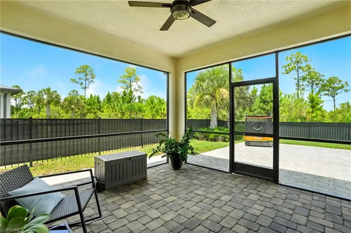 Sunroom / solarium with ceiling fan and a patio area