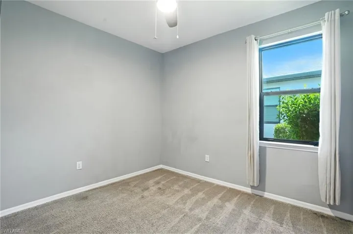 Unfurnished room featuring carpet flooring and ceiling fan