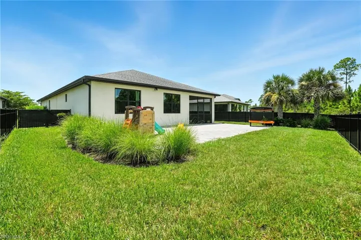 Back of house with a fenced backyard, a sunroom, stucco siding, and a patio