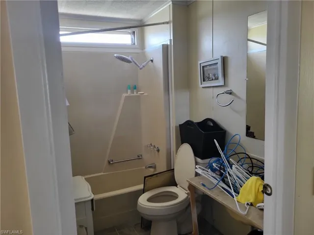 Bathroom featuring toilet, tile floors, and shower / bathtub combination