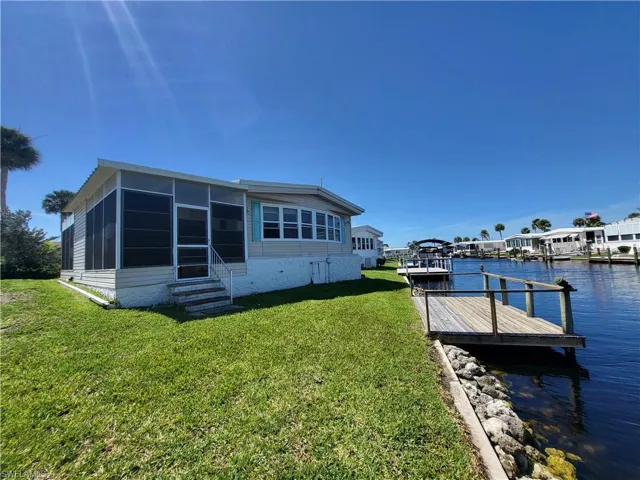 View of dock with a water view and a yard