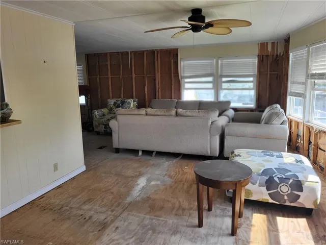 Living room featuring wooden walls and ceiling fan