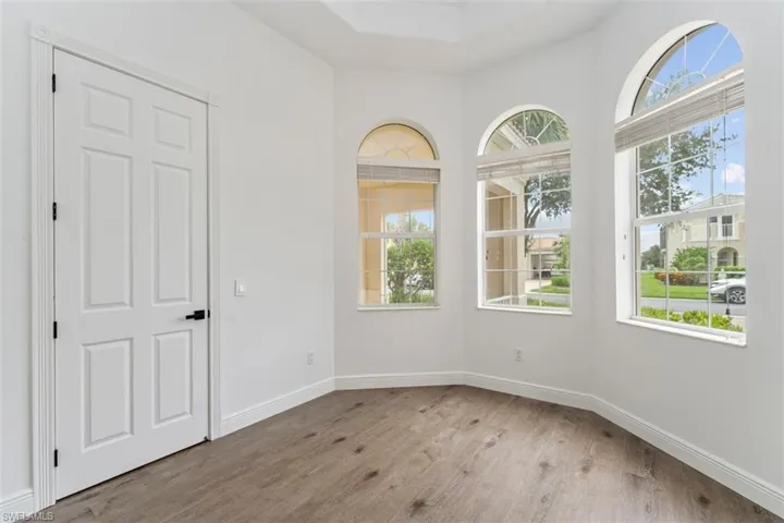 Unfurnished room with wood finished floors and plenty of natural light