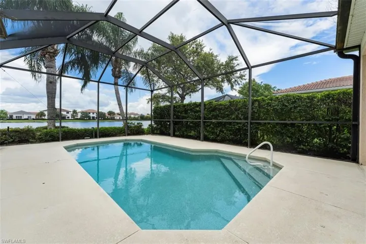 Outdoor pool with a patio, a water view, and a lanai