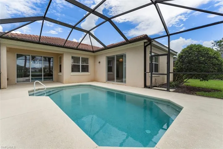 Outdoor pool with a patio and glass enclosure