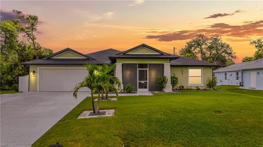 View of front facade featuring an attached garage, stucco siding, a sunroom, and concrete driveway