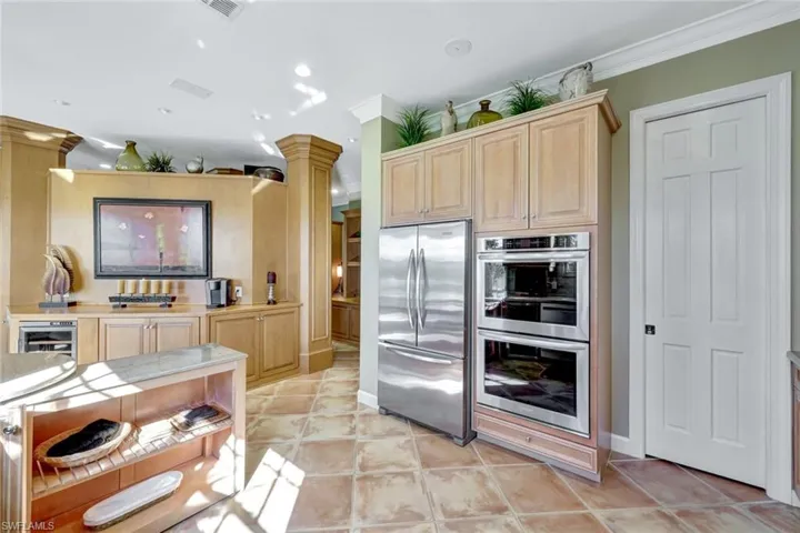 Kitchen with crown molding, wine cooler, decorative columns,