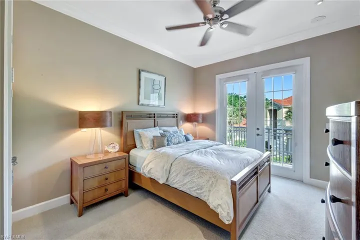 Bedroom #2 with light carpet, crown molding, and access to outside balcony