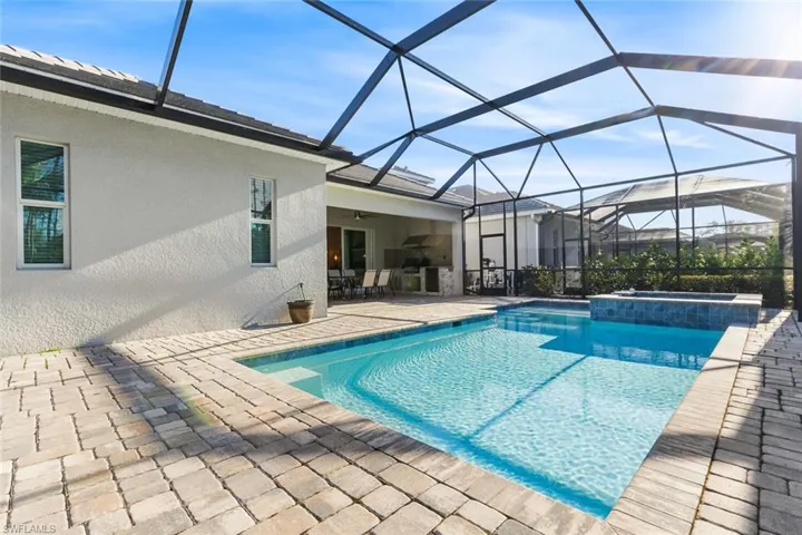 View of pool featuring a lanai, ceiling fan, a patio area, and an in ground hot tub