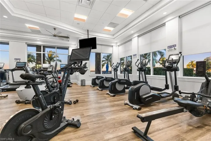 Exercise room featuring a tray ceiling, a paneled ceiling, and ceiling fan