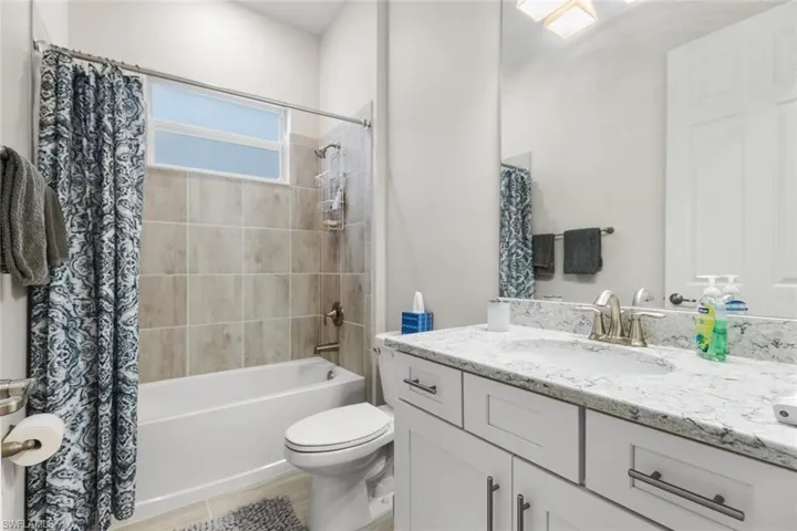 Full bathroom featuring shower / bath combo, vanity, and toilet