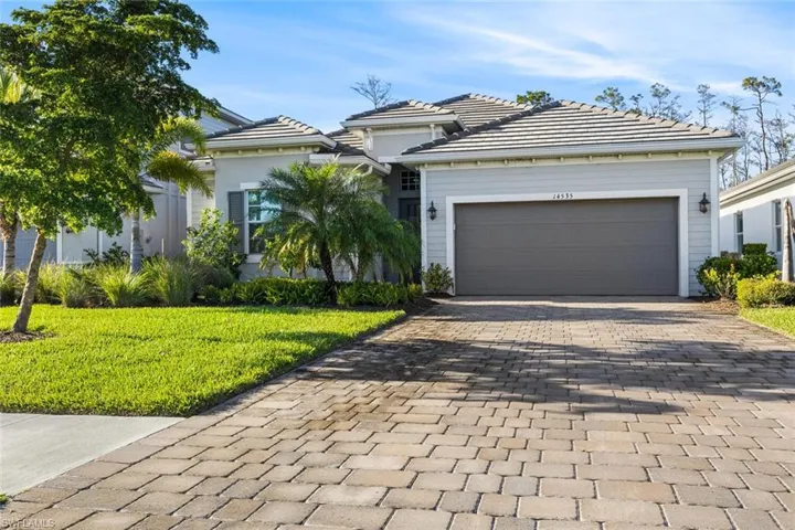 View of front of house featuring a garage and a front yard