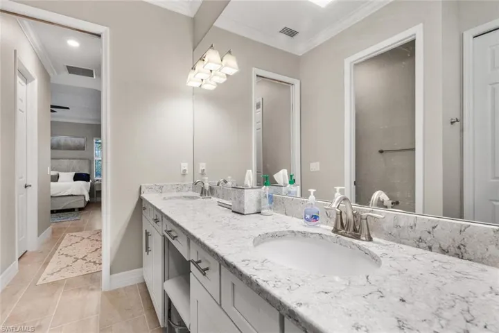 Bathroom featuring tile patterned floors, vanity, and crown molding