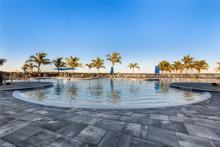 Pool at dusk featuring a patio