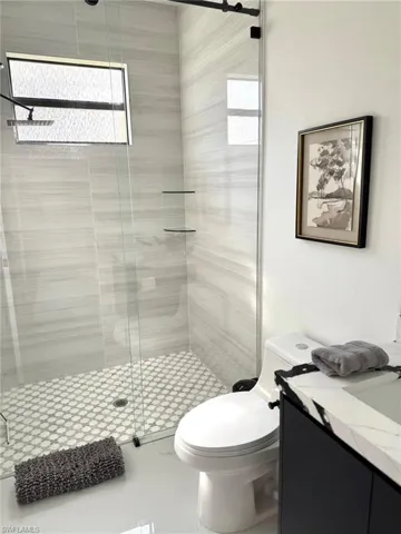 Full bathroom with vanity, a stall shower, and plenty of natural light