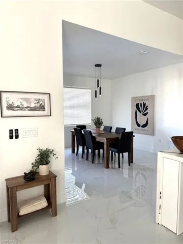 Dining space featuring baseboards and light marble finish flooring
