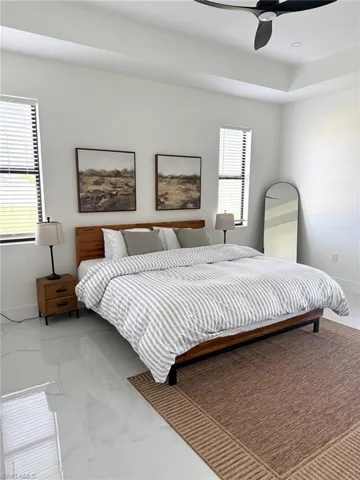 Bedroom with marble finish flooring and a ceiling fan